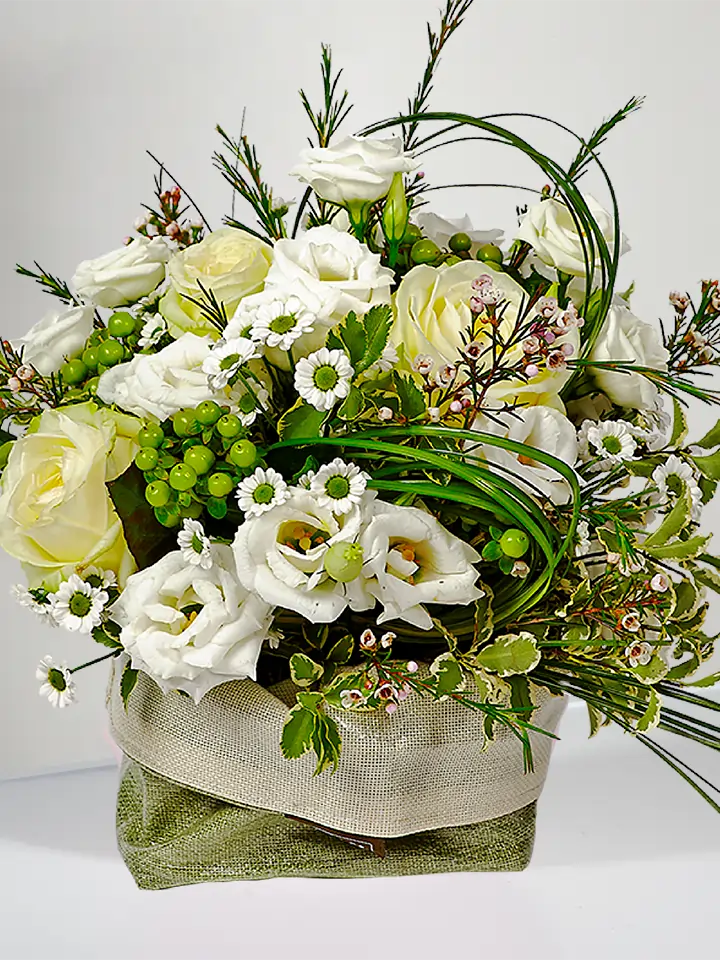 Centrotavola rose e lisianthus bianchi e bacche verdi close up